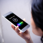 A woman holding her phone talking into for voice search.